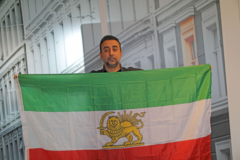 Aram Nour holder opp det iranske flaggene fra tiden før revolusjonen i 1979, der en løve holder et sverd i det hvite feltet. Løven er i dagens flagg erstattet med et symbol som ble godkjent av Ayatollah Khomeini, 9. mai 1980. Foto: Trygve Bergsland.